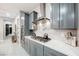 Modern kitchen with gray cabinets, marble countertops, and stainless steel appliances at 107 Reflection Cove Dr, Henderson, NV 89011