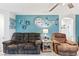 Living area with teal walls, two recliners, and a large clock at 2225 Chandler Ranch Pl, Laughlin, NV 89029