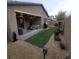 Landscaped backyard with covered patio, artificial turf, and grill at 2828 Shadows Edge Ct, Henderson, NV 89052