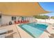 Relaxing rectangular pool with patio chairs under shade sail at 3829 Delaware Ln, Las Vegas, NV 89169