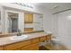 This bathroom features honey-colored cabinets and a shower-tub combo at 45 Maleena Mesa St # 223, Henderson, NV 89074