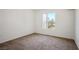 This bedroom features neutral carpet and a sunny window overlooking the property at 45 Maleena Mesa St # 223, Henderson, NV 89074