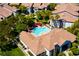 Aerial view showcases a community pool with palm trees, red umbrellas, and lush landscaping at 45 Maleena Mesa St # 223, Henderson, NV 89074