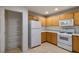 Kitchen with wood cabinets, white appliances, and pantry at 6005 Bristol Crest Ln, Las Vegas, NV 89139