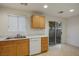 Kitchen features wood cabinets, white appliances and backyard access at 6005 Bristol Crest Ln, Las Vegas, NV 89139
