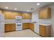 Galley kitchen with wood cabinets and white appliances at 6005 Bristol Crest Ln, Las Vegas, NV 89139