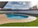 Kidney-shaped pool with artificial turf and covered patio at 8645 Edmond St, Las Vegas, NV 89139