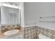 Bathroom with granite vanity, tile floor, and glass shelves at 10082 Swimming Hole St, Las Vegas, NV 89183