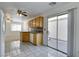 Kitchen with wood cabinets, tile floor, and sliding door to patio at 10082 Swimming Hole St, Las Vegas, NV 89183