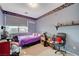 bedroom with purple bedding and city view at 10150 Timber Willow Ave, Las Vegas, NV 89135