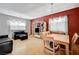 Bright dining area with wood table and red accent wall at 10150 Timber Willow Ave, Las Vegas, NV 89135