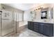 Bathroom with double vanity, soaking tub, and glass shower at 10444 Britton Hill Ave, Las Vegas, NV 89129