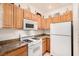 Bright kitchen with wood cabinets, granite counters, and white appliances at 108 Breezy Tree Ct # 202, Las Vegas, NV 89145