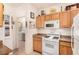 Kitchen features wood cabinets, granite countertops, and white appliances at 108 Breezy Tree Ct # 202, Las Vegas, NV 89145