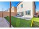 Artificial turf backyard with paver patio and a view of neighboring homes at 10931 Cambridge Lakes Ave, Las Vegas, NV 89166