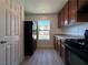 Kitchen with wood cabinets, black appliances and vinyl flooring at 1096 Country Coach Dr, Henderson, NV 89002