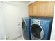 Laundry room with washer, dryer, and upper cabinets at 1526 Carriagedale Ct, Las Vegas, NV 89110