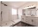 Modern bathroom with white cabinets, marble shower, and double vanity at 1781 Lakewood Dr, Henderson, NV 89012