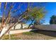 Landscaped backyard with mature trees and low wall at 2044 Glorieta Ln, Las Vegas, NV 89134