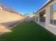 Landscaped backyard featuring artificial turf and a covered patio at 2110 Millergrove Ave, North Las Vegas, NV 89086