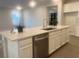 Modern kitchen island with sink, dishwasher, and white cabinets at 2110 Millergrove Ave, North Las Vegas, NV 89086