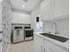 Bright laundry room with white cabinets and stainless steel washer/dryer at 2236 Waterton Rivers Dr, Henderson, NV 89044