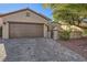 Single-story house with brown garage door and brick driveway at 2401 Weaverville Dr, Henderson, NV 89044