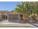 Single-story house with brown garage door and palm trees at 2401 Weaverville Dr, Henderson, NV 89044