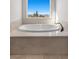 Bathroom with a large tub below a window and tile floor at 2717 Mona Lisa St, Henderson, NV 89044