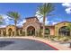 Attractive clubhouse exterior featuring stone archway, desert landscaping and two palm trees at 2717 Mona Lisa St, Henderson, NV 89044