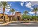 Exterior front view of clubhouse featuring a stone arch entrance with palm trees and desert landscaping at 2717 Mona Lisa St, Henderson, NV 89044