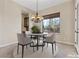 Cozy dining area with elegant chandelier, round table, and natural light from the large window at 2717 Mona Lisa St, Henderson, NV 89044