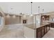 Open-concept kitchen and living area, featuring an island, fireplace, and tiled flooring at 2717 Mona Lisa St, Henderson, NV 89044