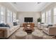 Staged living room with neutral furniture, large windows with shutters, and recessed lighting at 2717 Mona Lisa St, Henderson, NV 89044