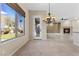 Open-concept living room with chandelier, fireplace, backyard view and tile flooring creates an inviting atmosphere at 2717 Mona Lisa St, Henderson, NV 89044