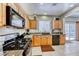 Bright kitchen with wood cabinets, granite countertops, and black appliances at 2744 Drummossie, Las Vegas, NV 89044