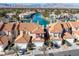 This aerial view of the home features the waterfront location, terra cotta roof, and mountain views at 3173 Lido Isle Ct, Las Vegas, NV 89117