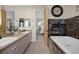 Bathroom featuring double sinks, fireplace next to a tub and a doorway to the bedroom at 3173 Lido Isle Ct, Las Vegas, NV 89117