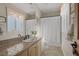 Well-lit bathroom featuring a window, tile countertop, framed mirror, and shower-tub combo at 3173 Lido Isle Ct, Las Vegas, NV 89117