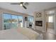 Bright bedroom featuring a white bed frame, wood floors, fireplace and balcony access at 3173 Lido Isle Ct, Las Vegas, NV 89117