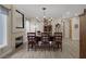 Bright dining area with a stone fireplace, wood-burning stove, wooden dining table set for six, and hardwood flooring at 3173 Lido Isle Ct, Las Vegas, NV 89117