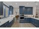 Charming kitchen featuring blue cabinetry, white countertops, stainless appliances, and a farmhouse-style sink with great views at 3173 Lido Isle Ct, Las Vegas, NV 89117