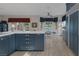 Spacious kitchen featuring blue cabinets, marble countertops, and an adjacent breakfast nook with views of the pool at 3173 Lido Isle Ct, Las Vegas, NV 89117