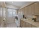 Convenient laundry room features a utility sink and updated appliances next to a window at 3173 Lido Isle Ct, Las Vegas, NV 89117