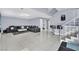 Spacious living room with sleek, black sectional sofa and high-gloss floors at 3380 Shallow Pond Dr, Las Vegas, NV 89117