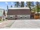 Gray metal exterior home with brown roof, paved driveway, and landscaping at 4765 Silver Tip Trl, Mount Charleston, NV 89124