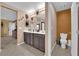 Double vanity bathroom with a toilet and decorative wall art at 4823 Kinworthy St, North Las Vegas, NV 89081