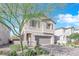 Two-story house with gray garage door and gray shutters, tree in front at 4823 Kinworthy St, North Las Vegas, NV 89081