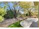 Landscaped backyard with a flagstone patio and lush greenery at 5026 Vincitor St, Las Vegas, NV 89135