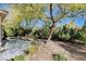 Landscaped backyard with mature trees and patio at 5026 Vincitor St, Las Vegas, NV 89135